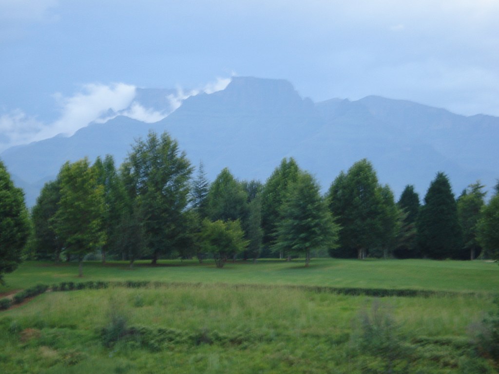 Photographie de Cathkin Peak, 3182 m au-dessus du niveau de la mer au premier plan, et Champagne Castle, 3377 m au-dessus du niveau de la mer, entouré de nuages à l'arrière-plan.