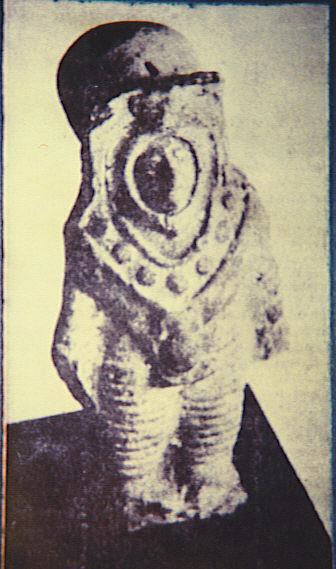 Photo du livre de Wendelle Stevens d'une autre statuette avec un personnage en combinaison spatiale montrant une tête allongée dans le casque.