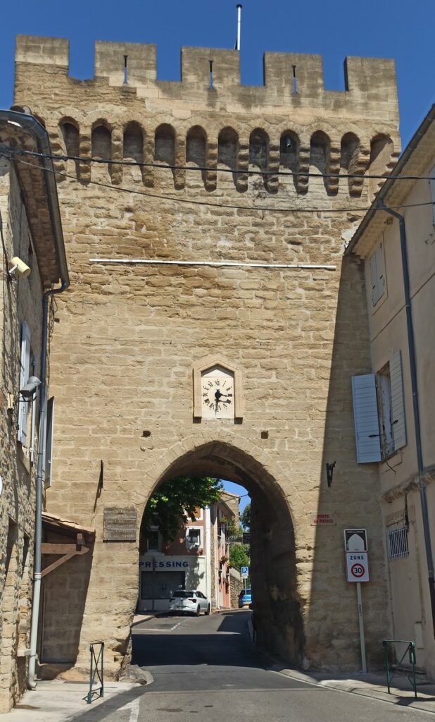 L'horloge électrique sur la porte médiévale que décrit Pierre Monnet, prise en photo à Courthézon par le rédacteur de cet article au début du mois d'août 2025.