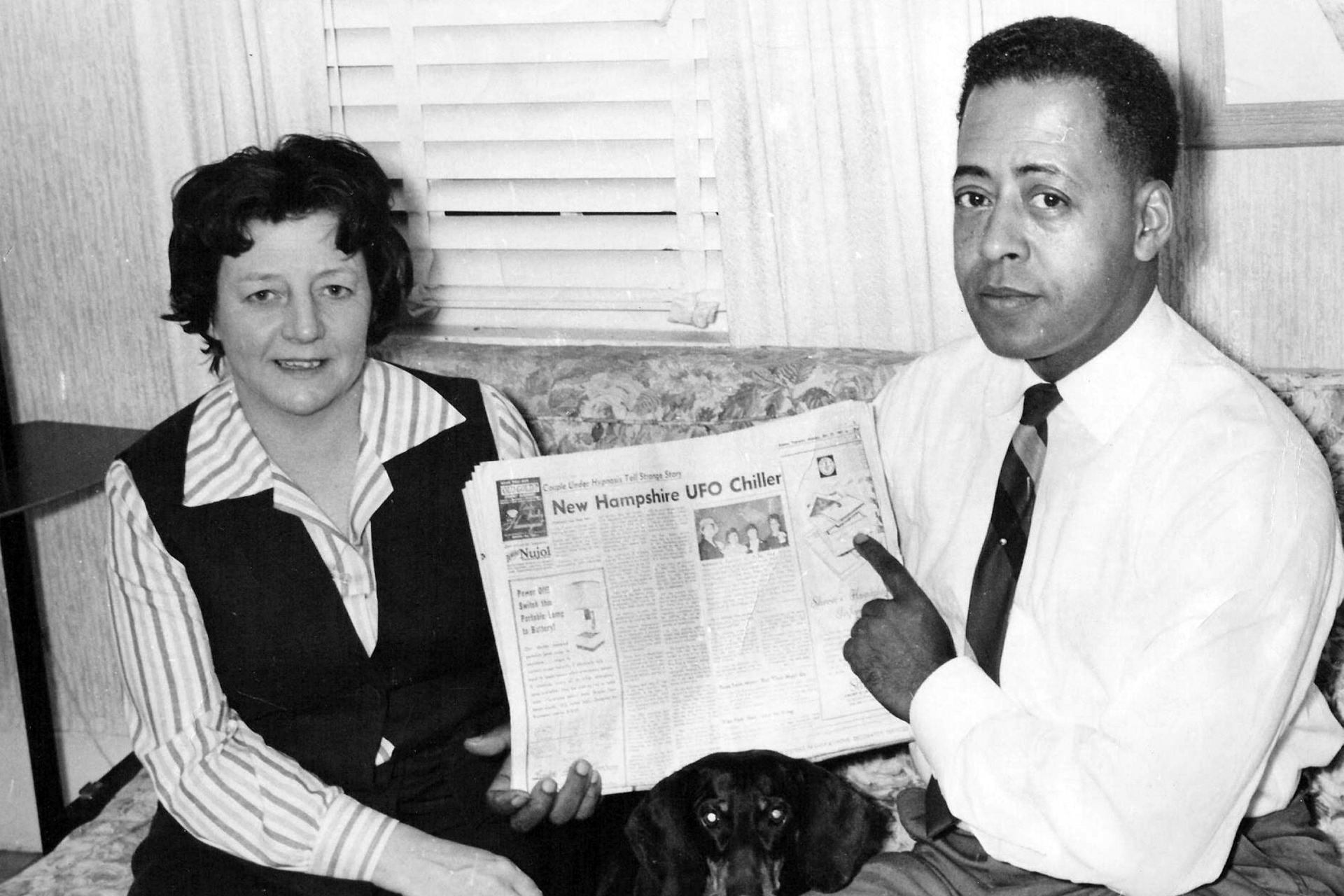 Barney et Betty Hill, avec un article de journal sur leur enlèvement.