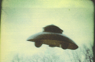 Photographie extraite du film en 8mmdu film fait par Madeleine Rodeffer en la présence de George Adamski. On voit la surface de l’appareil se déformer en livre pendant le film, à cause de la déformation des rayons lumineux dues aux vagues d’antigravité autour de l’appareil. Cette déformation sera la meilleure preuve de la réalité de ce qui est filmé. L’appareil n’est pas « de travers » comme le montre la photo, c’est une déformation optique. Les 3 boules du dessous (qui sont des condensateurs électriques creux selon explication qui a été donnée à Adamski et servent aussi de tripode d’atterrissage) sortent et se rétractent tout du long de la vidéo.