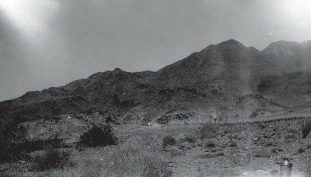 La première photo « Brownie » améliorée, assombrie pour mettre en évidence le coin supérieur gauche, tandis que la zone où se trouve Alfred Bailey a été éclaircie afin de montrer la silhouette en relation avec le paysage réel, il est sur place et montre le ciel dans la direction où se trouve le vaisseau cigare… À environ 18 mètres à gauche d’Alfred Bailey, on distingue le tube optique blanchâtre du télescope d’Adamski, posé au sol contre ce qui ressemble à une boîte en carton. Il n’a pas encore été installé sur son trépied.