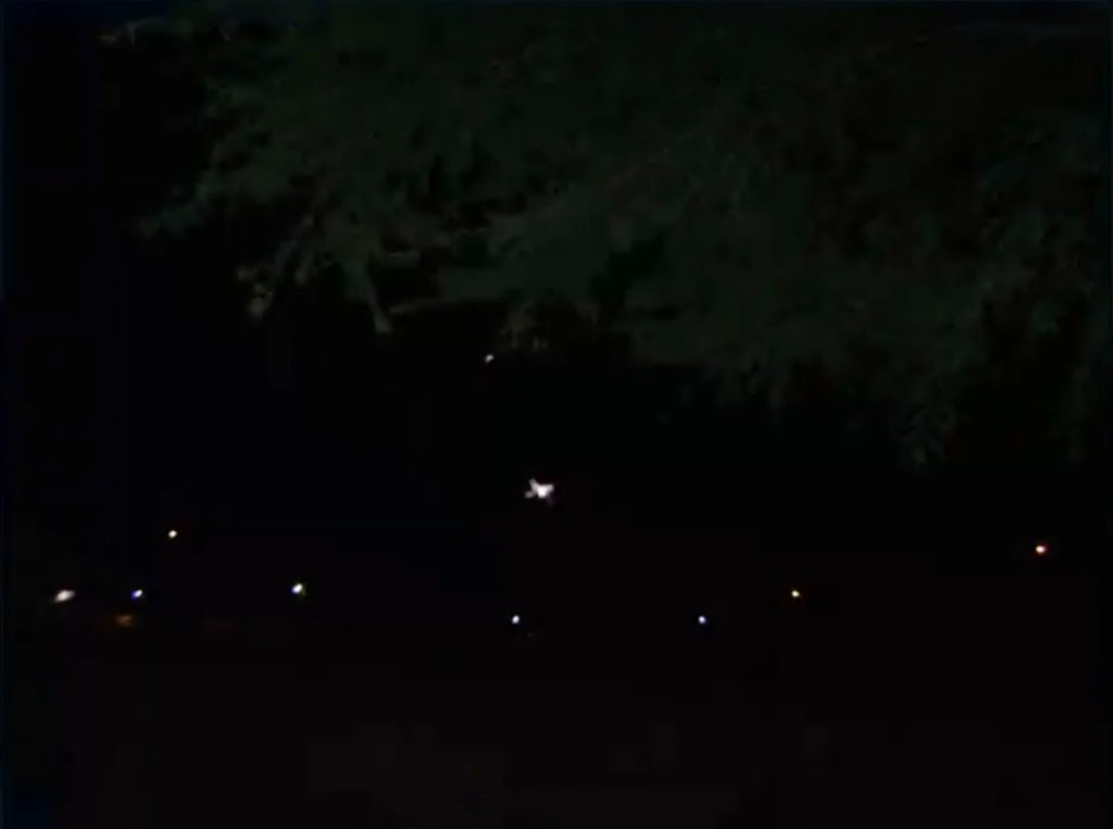 Photo du ciel de nuit prise par José Yaguana depuis son lieu de résidence. En bas une rangée de lampadaires, dans le ciel plus haut, un objet lumineux large et un plus petit objet lumineux plus haut encore. Ces deux objets sont des vaisseaux de Ectom.